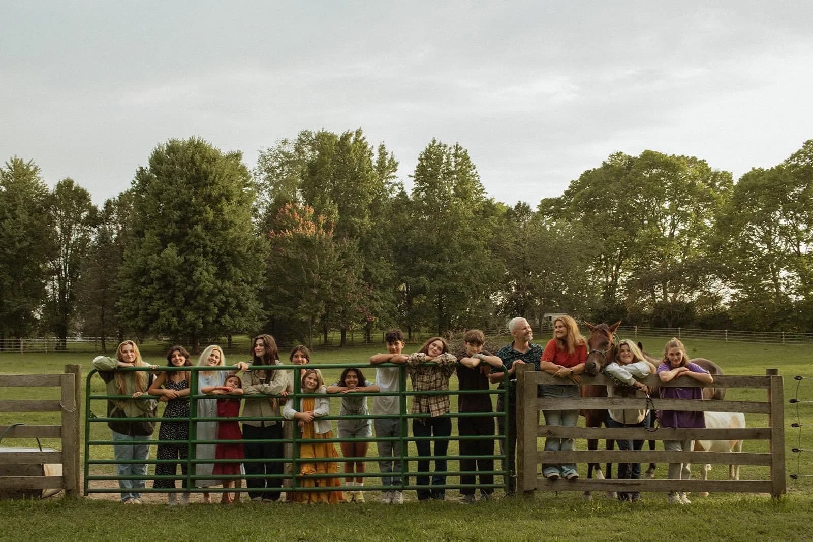 The Brown family lined up along a farm fence